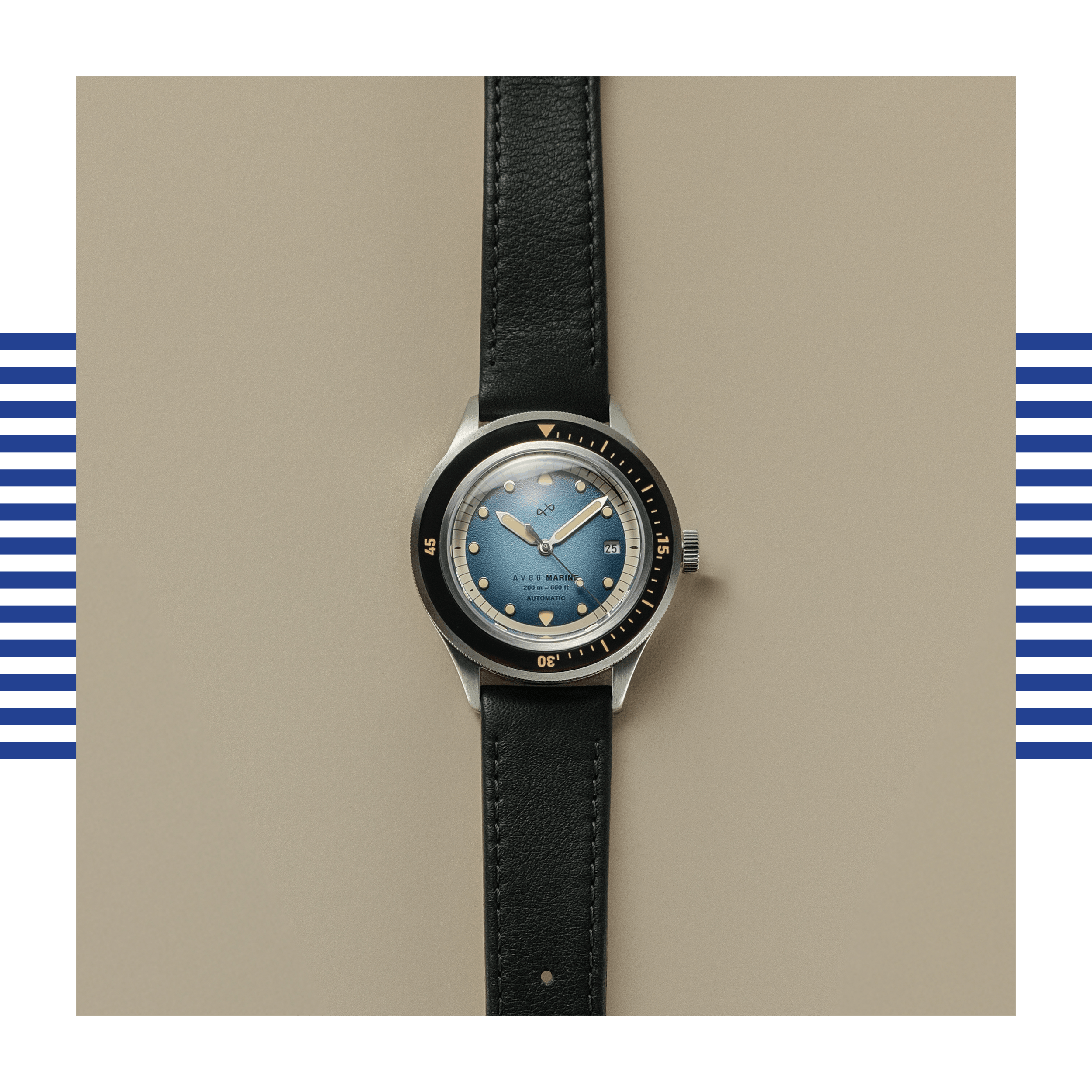 Wristwatch with a faded blue dial, black bezel, and black leather strap displayed on a neutral beige surface.