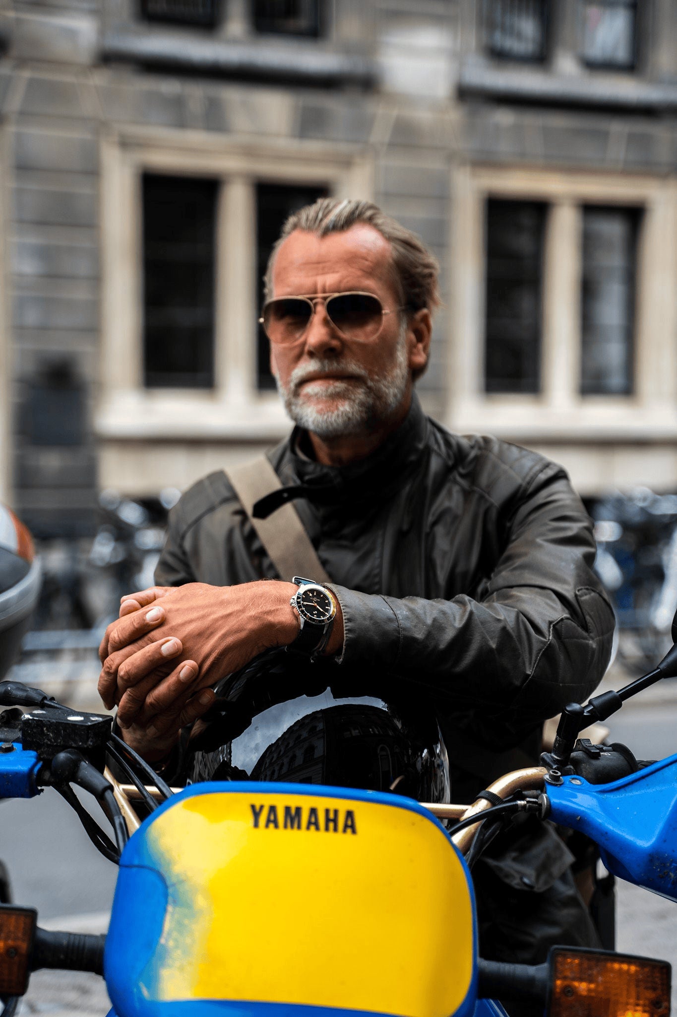 1970 Haagen GMT Automatic, Swiss Made by AV86 vintage-inspired GMT watch with sapphire crystal and black leather strap worn on wrist riding Yamaha bike