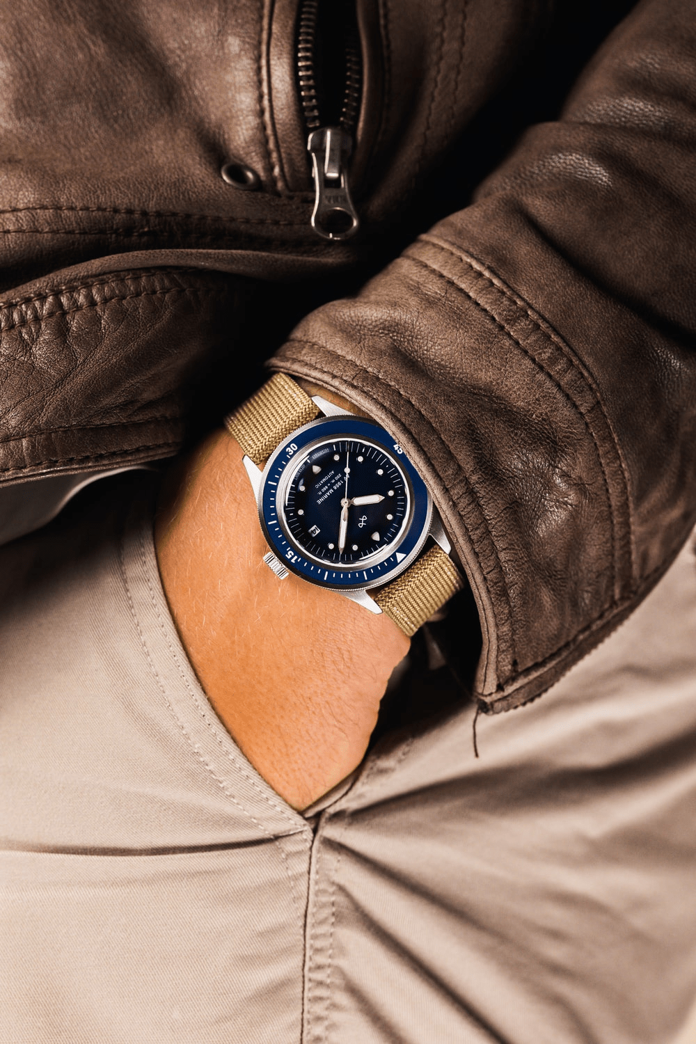 1956 Marine Automatic by AV86 vintage-inspired diver with sapphire crystal, rotating bezel, and fabric strap in casual leather jacket setting
