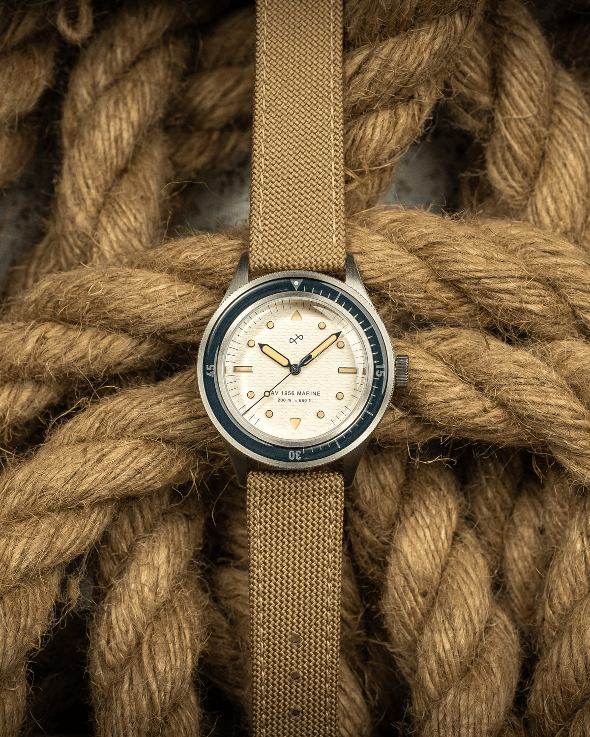 1956 Marine by AV86 vintage-inspired diver with acrylic bezel, luminous markers, and textured fabric strap on nautical rope background