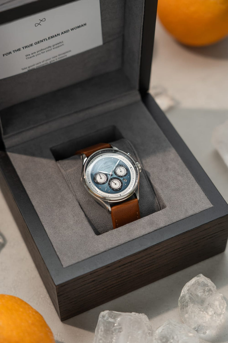 1564 Chronodate Automatic featuring a detailed chronograph dial with sapphire crystal, housed in a polished case with a brown leather strap, presented in a luxury AV86 watch box.