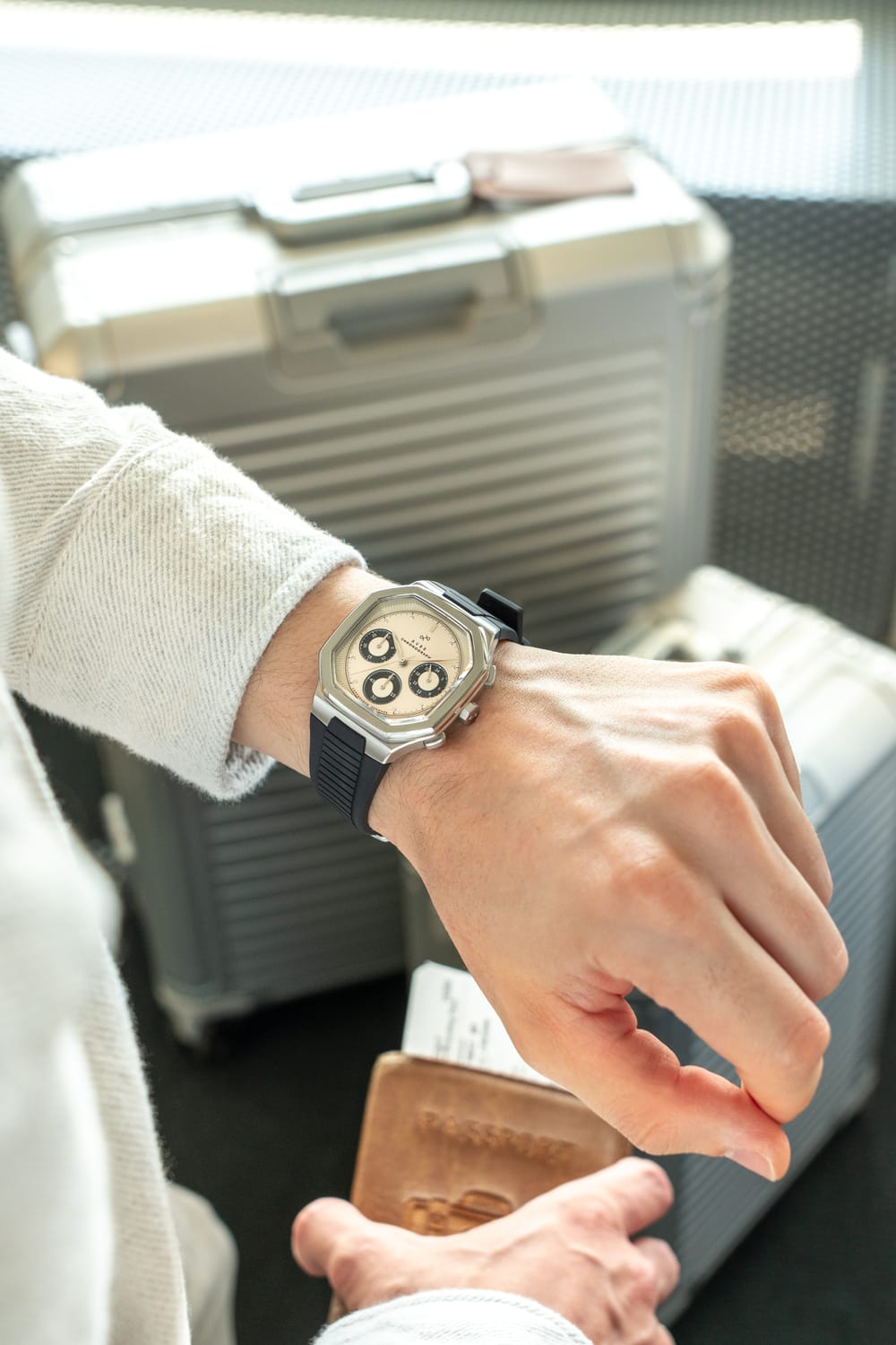 1904 Chronograph by AV86 angular case with sapphire crystal, chronograph dial, and black textured rubber strap on wrist in travel setting