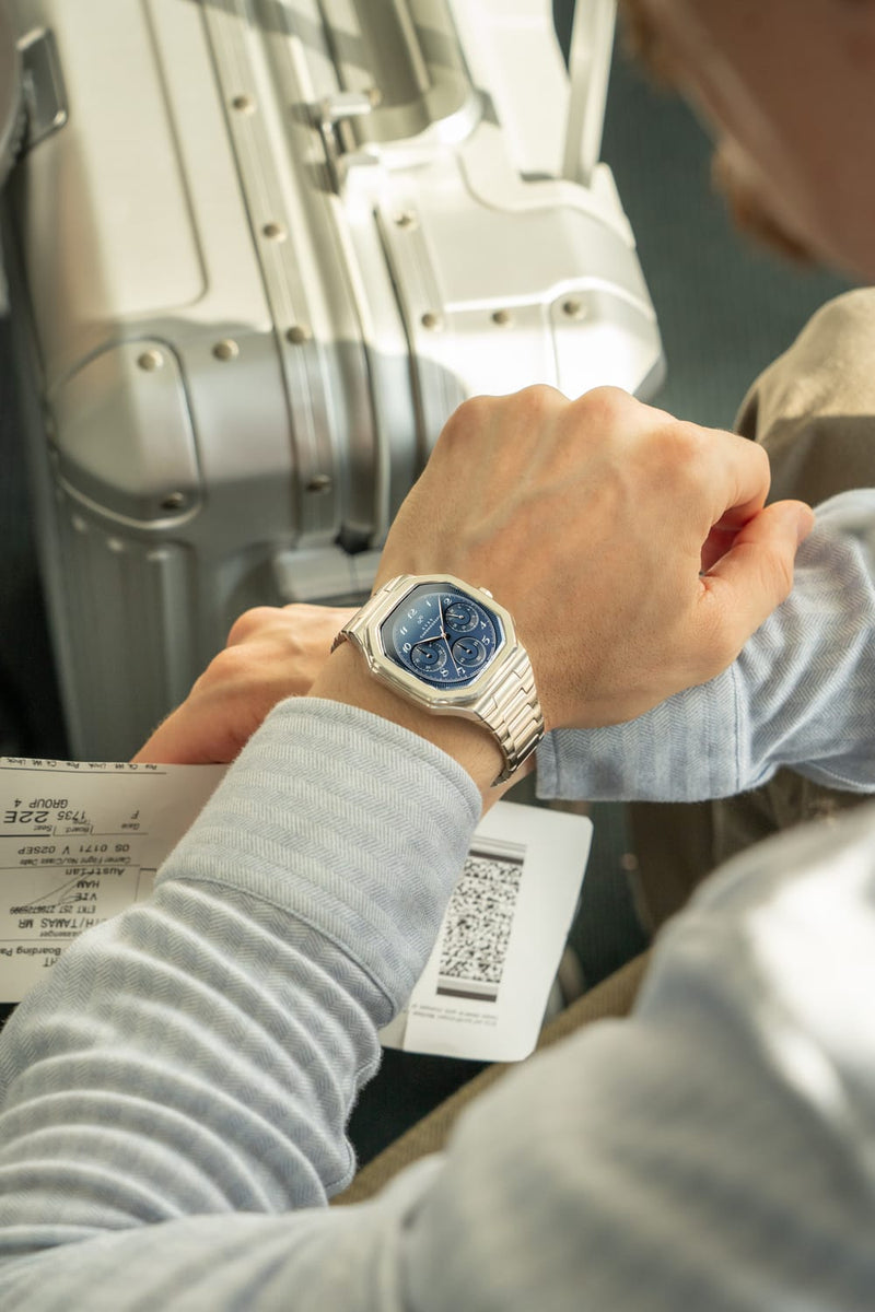 1904 Chronograph by AV86 with angular case, sapphire crystal, blue dial, chronograph function, and steel bracelet strap worn during travel