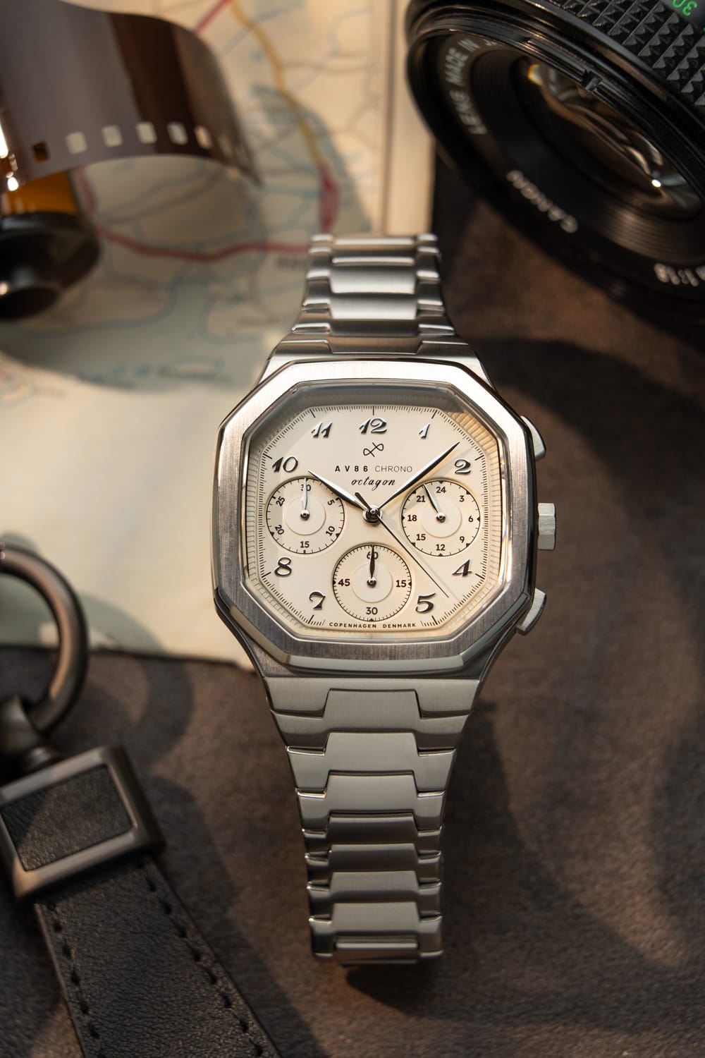 The 1904 Chrono, Steel / Off White by AV86 features a polished octagonal steel case with a classic chronograph dial, elegant Arabic numerals, and a brushed steel link bracelet, exuding refined Nordic minimalism in a vintage-inspired luxury timepiece.