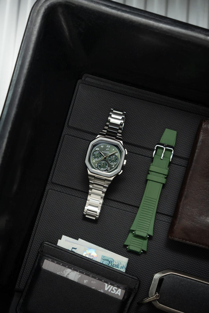 1904 Chronograph by AV86 with angular case, vintage-inspired dial, sapphire crystal, steel bracelet, and olive green rubber strap
