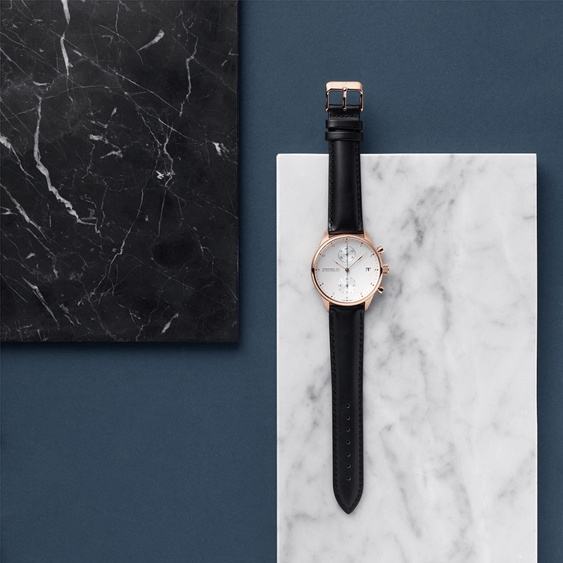 1815 Chronograph, Rose Gold / White by AV86 luxury chronograph with sapphire crystal, rose gold case, and black leather strap on marble background