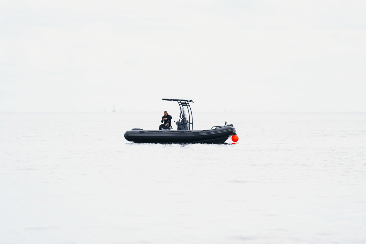 1956 Marine Automatic by AV86 minimalist nautical scene with diver aboard black RIB boat in calm open water
