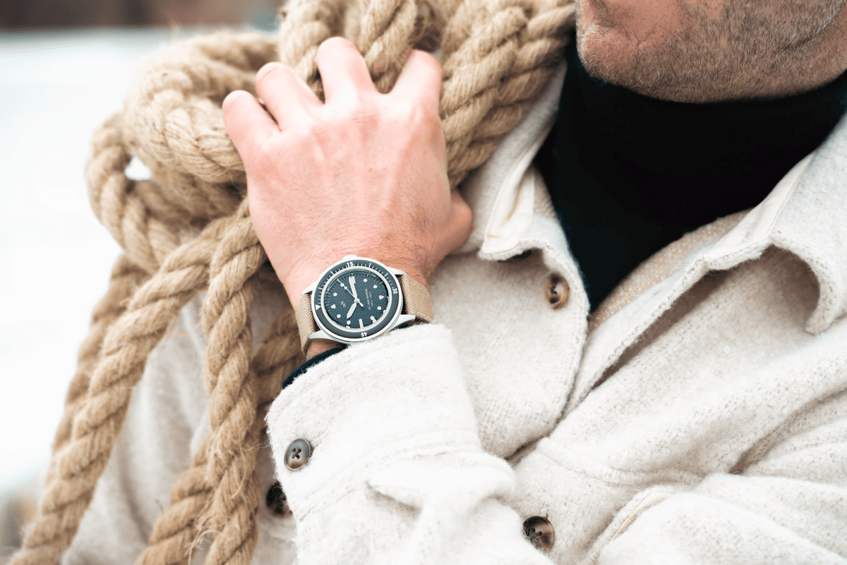 1956 Marine by AV86 vintage-inspired diver with acrylic filled bezel, luminous markers, and beige leather strap on wrist outdoors