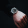 1564 Chronodate Automatic by AV86 with vintage chronograph dial, sapphire crystal, and black leather strap on wrist in minimalist setting