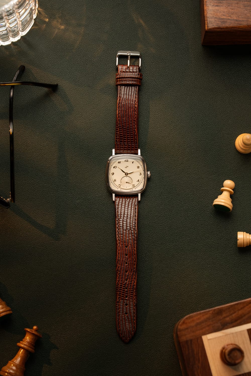 1954 Amalfi Mechanical, Steel / Off White vintage-inspired watch by AV86 with brown leather strap on dark surface with chess pieces