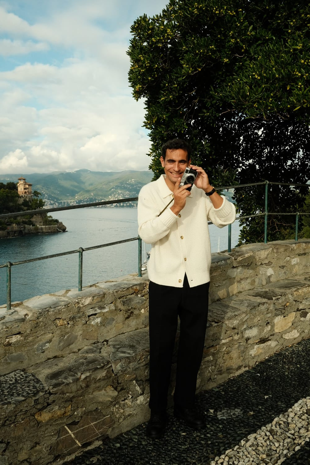 Man in relaxed Scandinavian attire standing by Mediterranean coast wearing 1954 Amalfi Mechanical, Gold / Midnight Blue by AV86