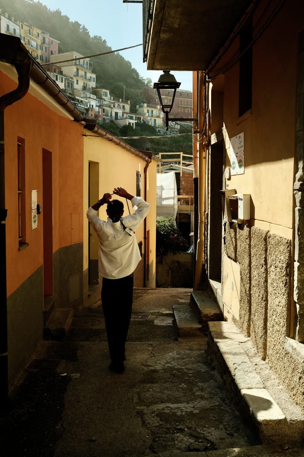Man in refined Scandinavian outfit strolling through sunlit alley, embodying timeless style with 1954 Amalfi Mechanical by AV86