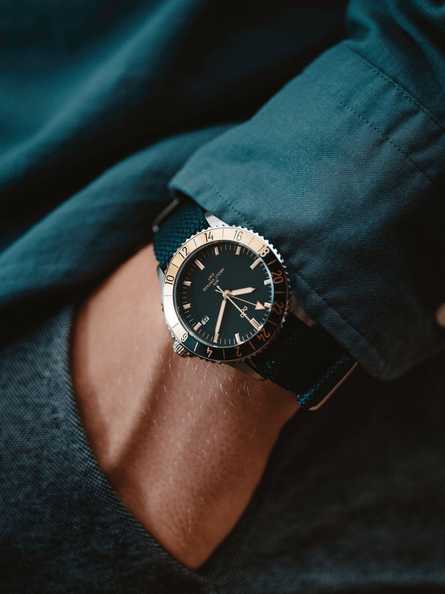 1970 Haagen GMT Automatic by AV86 with vintage-inspired dial, sapphire crystal, compass bezel, and textured fabric strap on wrist