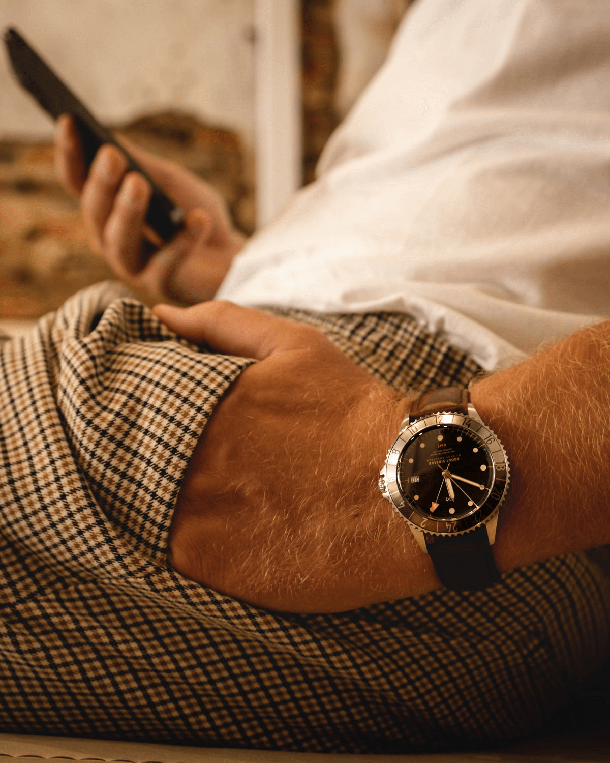 1982 GMT World Traveler by AV86 luxury GMT quartz watch with sapphire crystal, rotating bezel, and black leather strap in casual setting