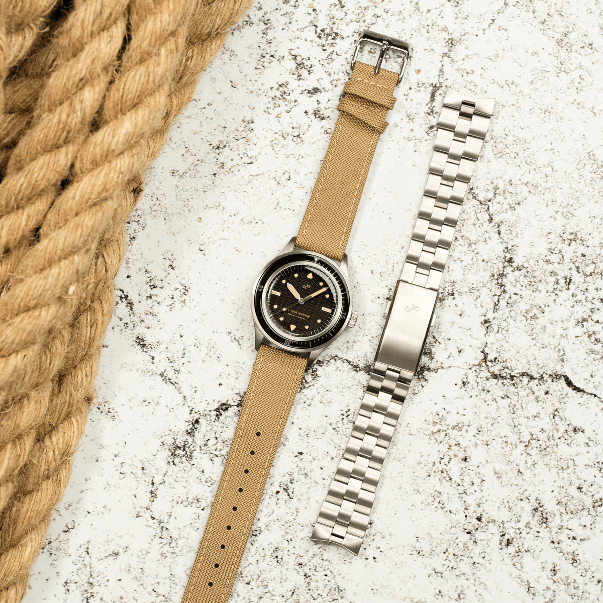 1956 Marine by AV86 vintage-inspired diver with acrylic filled bezel, large luminous markers, beige fabric strap, and metal bracelet option