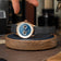1968 Moonphase, Rose Gold / Dark Blue by AV86 luxury moonphase watch with sapphire crystal and black leather strap on wooden stand