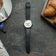 1564 Chronodate Automatic by AV86 features a vintage-inspired automatic chronograph with a refined white dial, multiple subdials, sapphire crystal, and a smooth black leather strap, exemplifying Danish horological craftsmanship and Nordic minimalism, styled alongside a breakfast setting with coffee, croissants, and a newspaper.