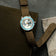 Earthrise WWF Partnership, Automatic / 2026 Edition by AV86 with a blue bezel and brown fabric strap, beside map and leather folio
