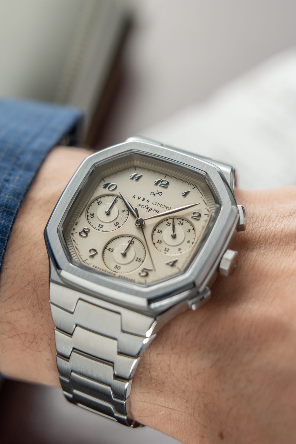 1904 Chrono, Steel / Off White luxury chronograph on wrist featuring a hexagonal stainless steel case, off white dial with three subdials, and integrated steel bracelet by AV86, embodying Nordic minimalism and Copenhagen design craftsmanship.