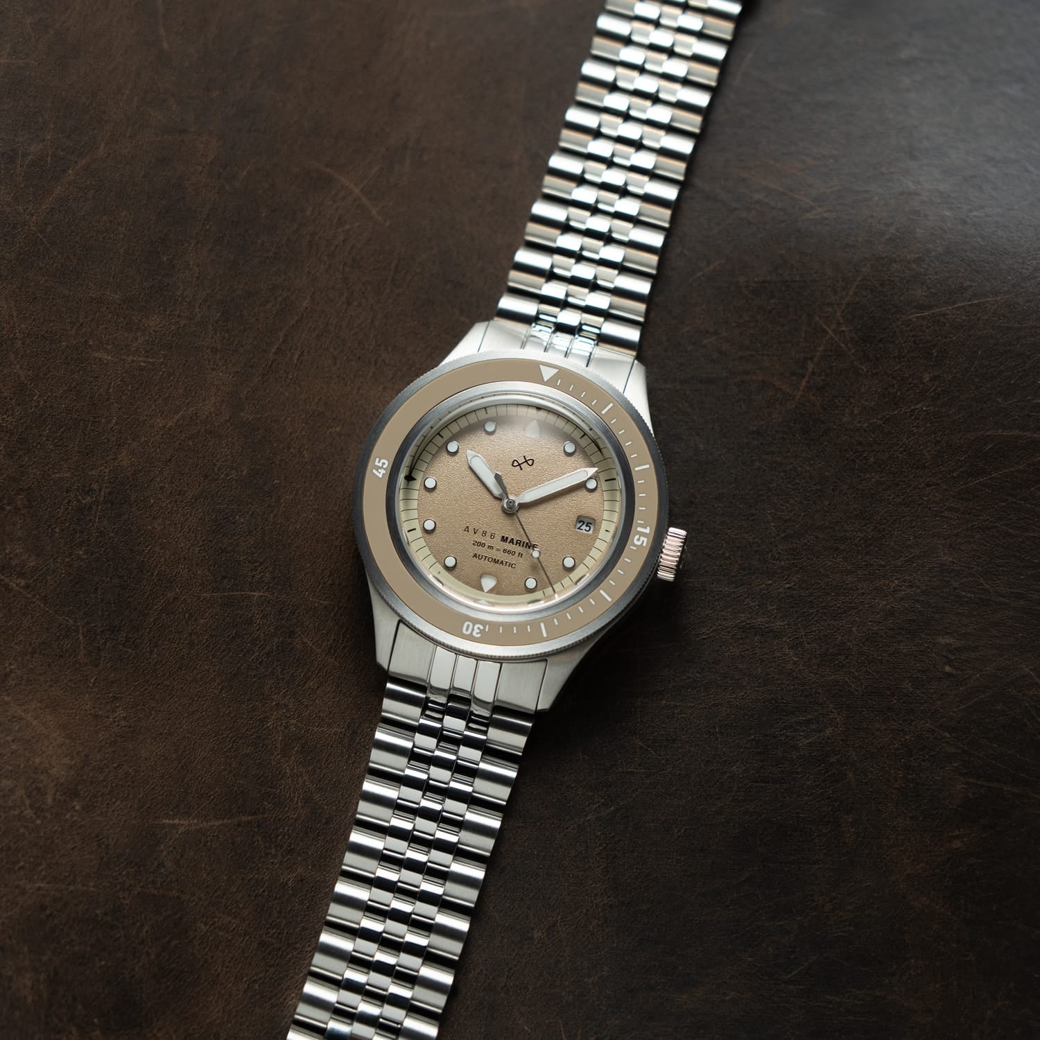 1956 Marine Automatic, Steel / Sand wristwatch by AV86 with a steel bracelet and sand-colored dial on dark brown background