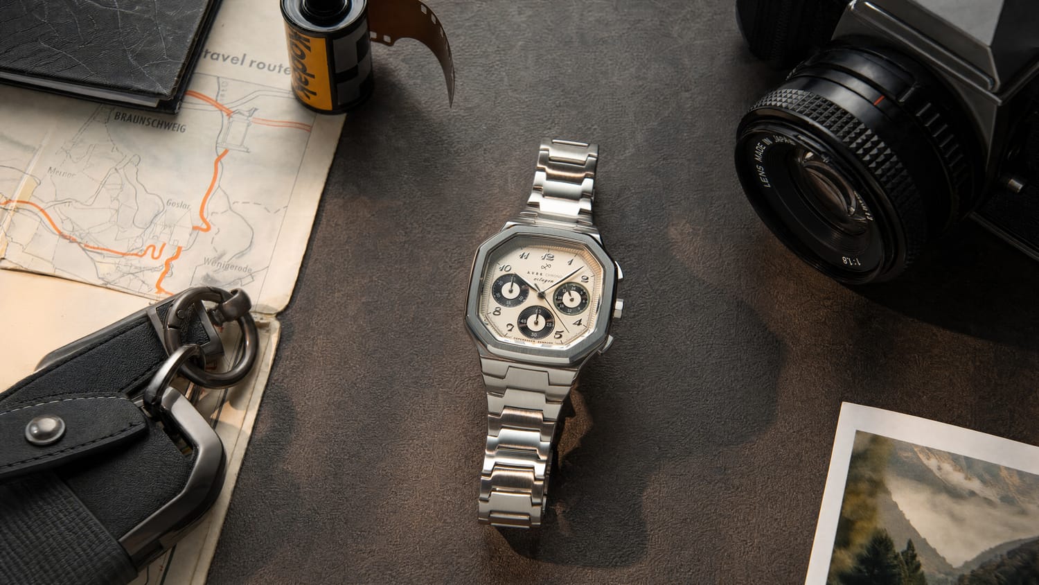 1904 Chrono with a brushed steel case and bracelet, featuring three chronograph subdials and a sapphire crystal, styled with vintage camera gear for a Nordic minimalist aesthetic by AV86.