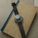 1956 Marine Automatic, Steel / Blue Fade vintage-inspired watch by AV86 with leather strap and blue gradient dial on a book background