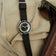 1956 Marine by AV86 vintage-inspired diver with sapphire crystal, compass bezel, and black fabric strap on beige fabric background
