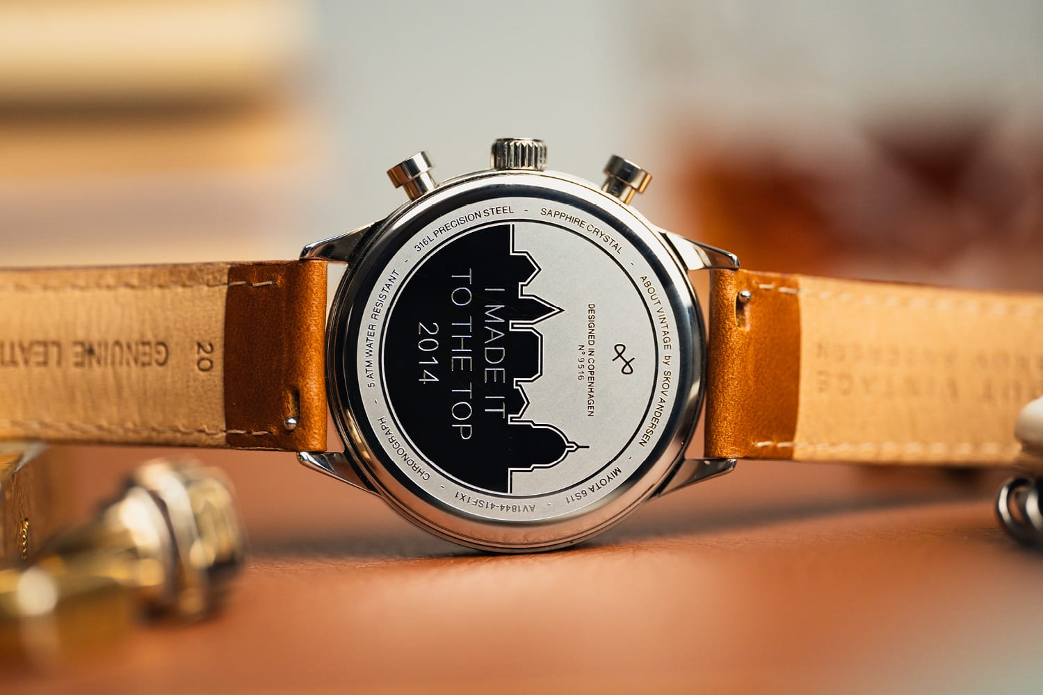AV86 chronograph back with sapphire crystal, steel case, engraved cityscape, and genuine leather strap, vintage-inspired design