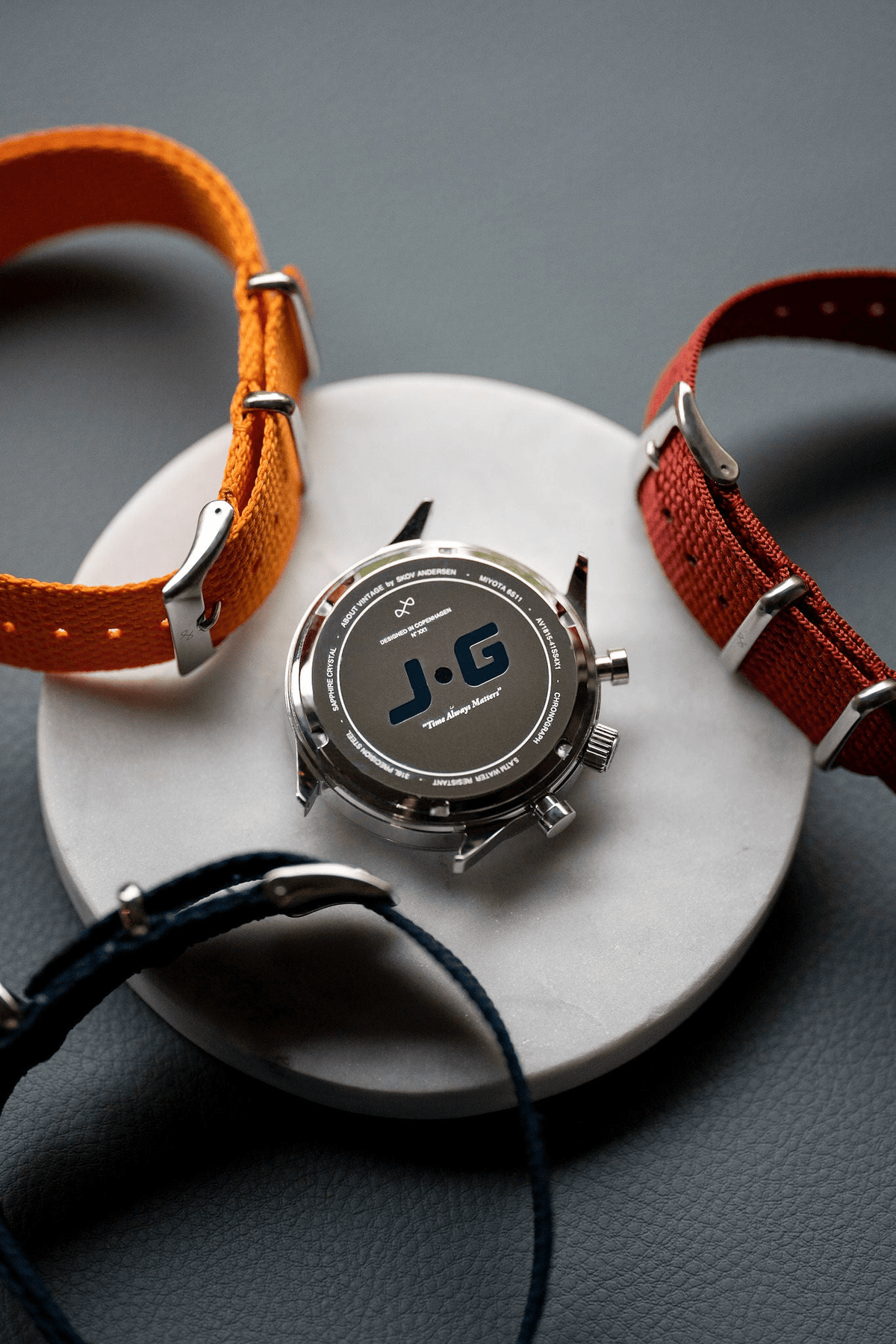 1815 Justin Gatlin, Gold / Blue Turtle by AV86 chronograph case back alongside interchangeable fabric NATO straps in orange, red, and blue