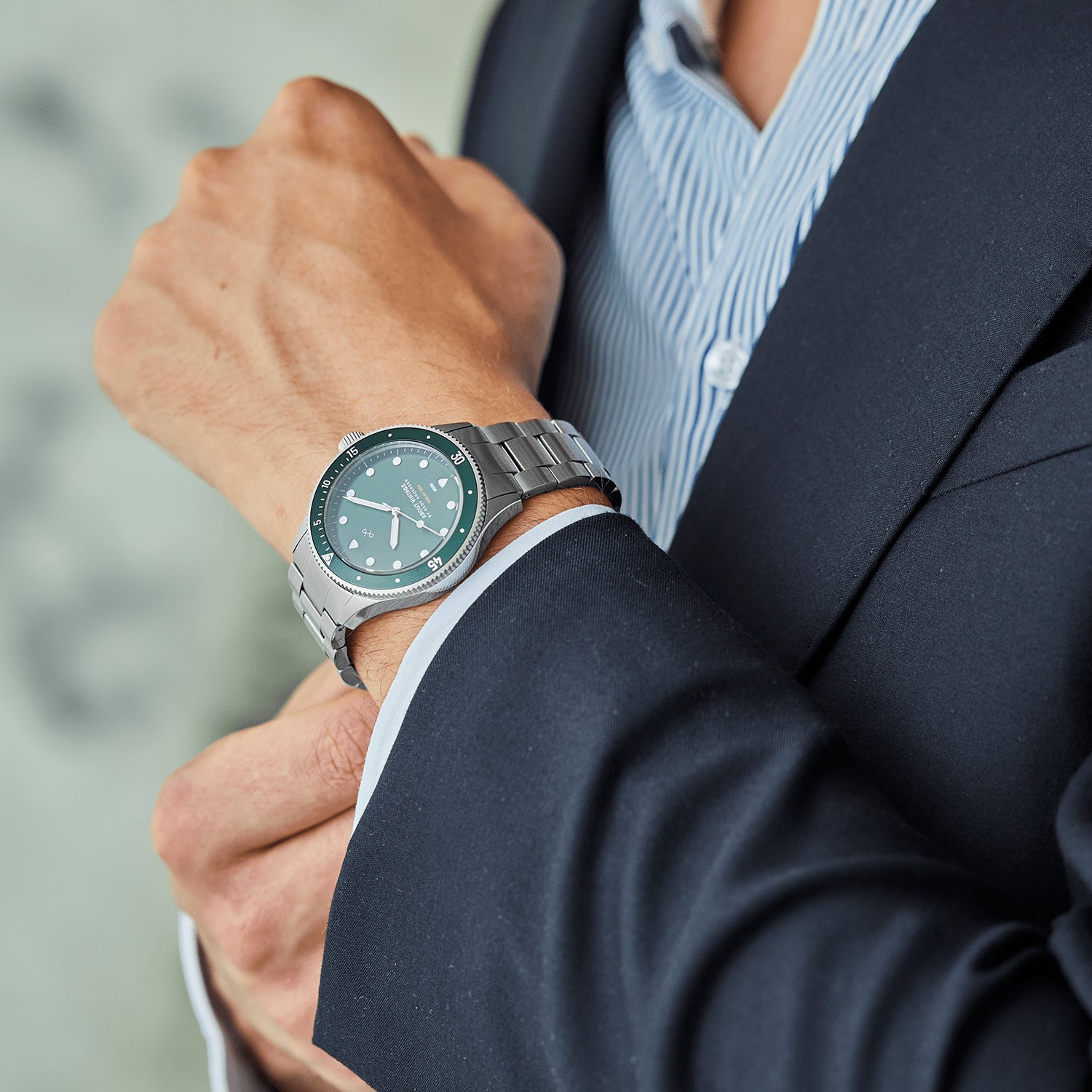 1926 At'sea by AV86 vintage-inspired diver with sapphire crystal, compass bezel, and stainless steel bracelet strap worn with suit